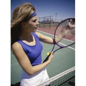  Young Woman Holding a Tennis Racket Standing Near a Net 